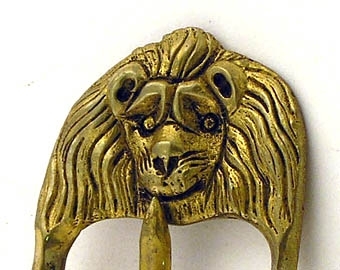Spänne av mässing, ornerat med två lejonhuvuden.