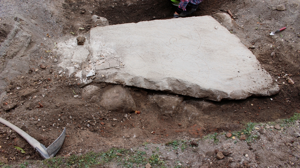 Arkeologisk schaktningsövervakning och undersökning, runstenen med stenar som tolkas som fundament, Hagby kyrka, Hagby socken, Uppland 2016