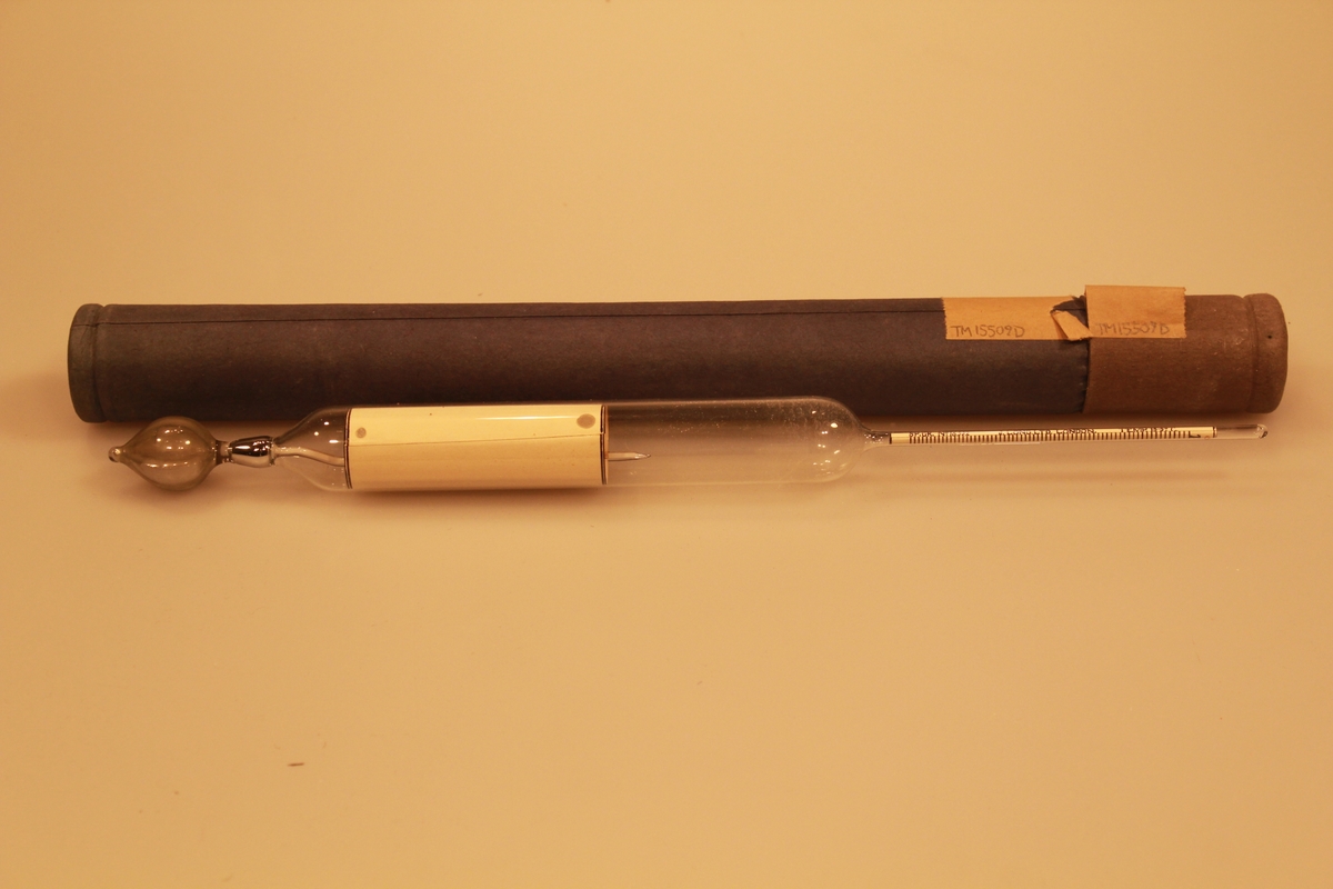 Måleinstrument med kvikksølv, for verdier i melken ved 15,5 grader. Det har en sylindrisk form med innsnevring to steder. Instrumentet ligger i original embalasje.