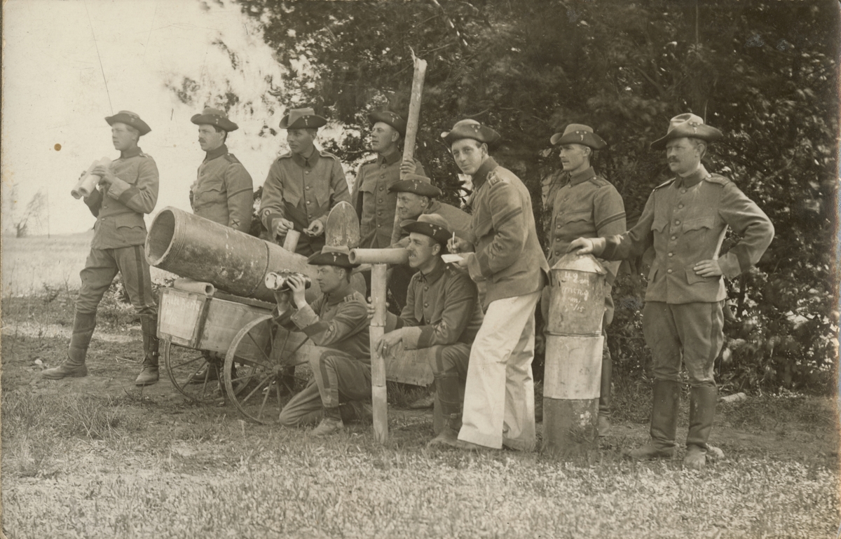 Gruppbild med soldater från Positionsartilleriregemente A 9 bakom en självbyggd "artilleripjäs".