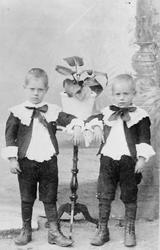 To små gutter, klær, blomsterpotte m/blomst.