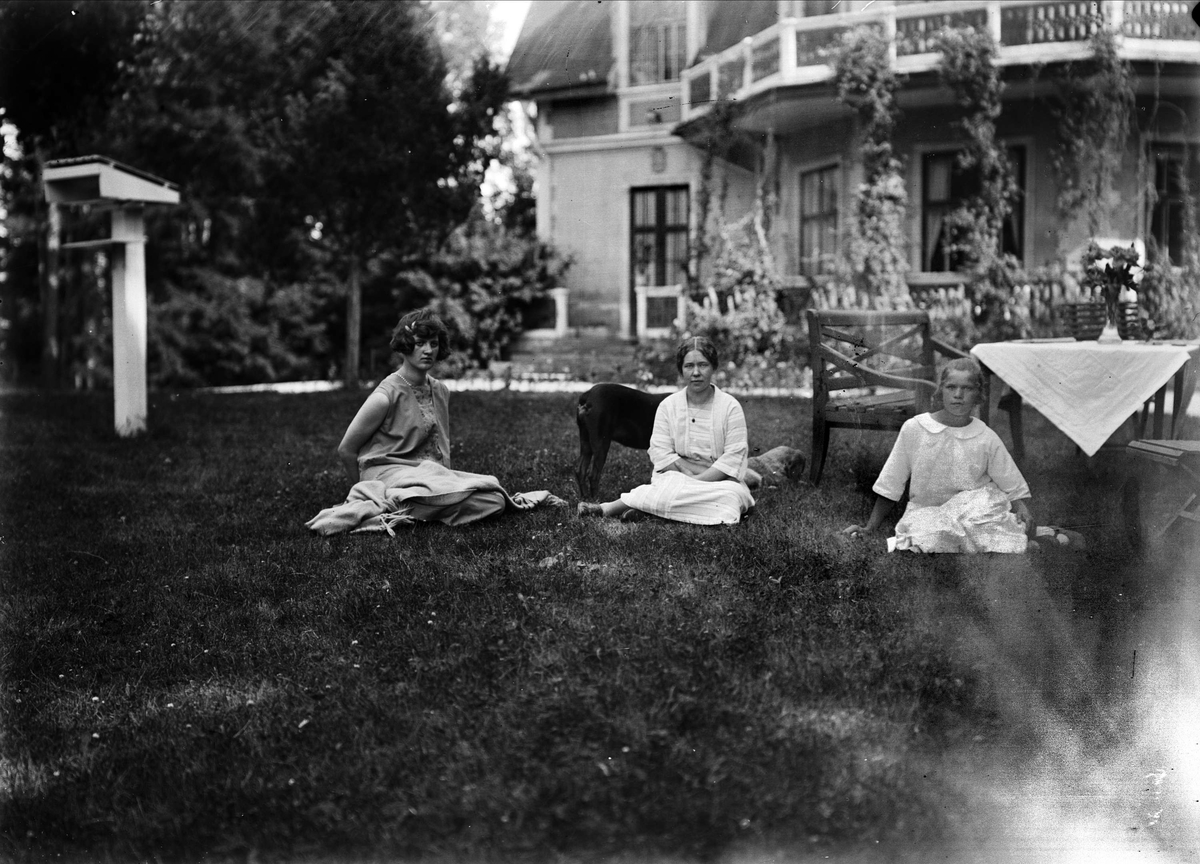 Husan Alice Vestrin Göksbo jämte kokerskan Frida Gustafsson och springflickan sittande på gårdsplanen, Altuna socken, Uppland 1926