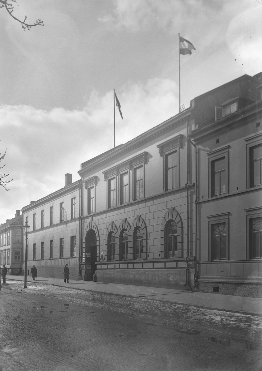 Kjøpmannsgata med eiendommene til A. Mendelsohn & Sønner konfeksjonsfabrikk med det tyske konsulat med flagg på taket med hakekors