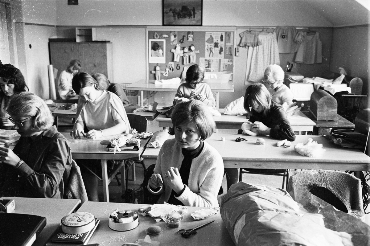 Unga kvinnor syr i slöjdsalen på husmodersskolan, Uppsala stads yrkesskola i Sunnersta folkskola