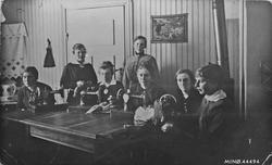 Kvinner, symaskiner, inne i ett hus.