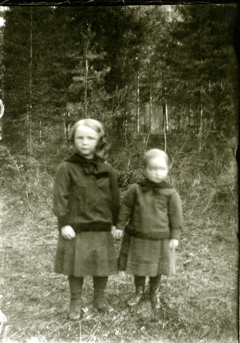 To barn står ute i skogen.