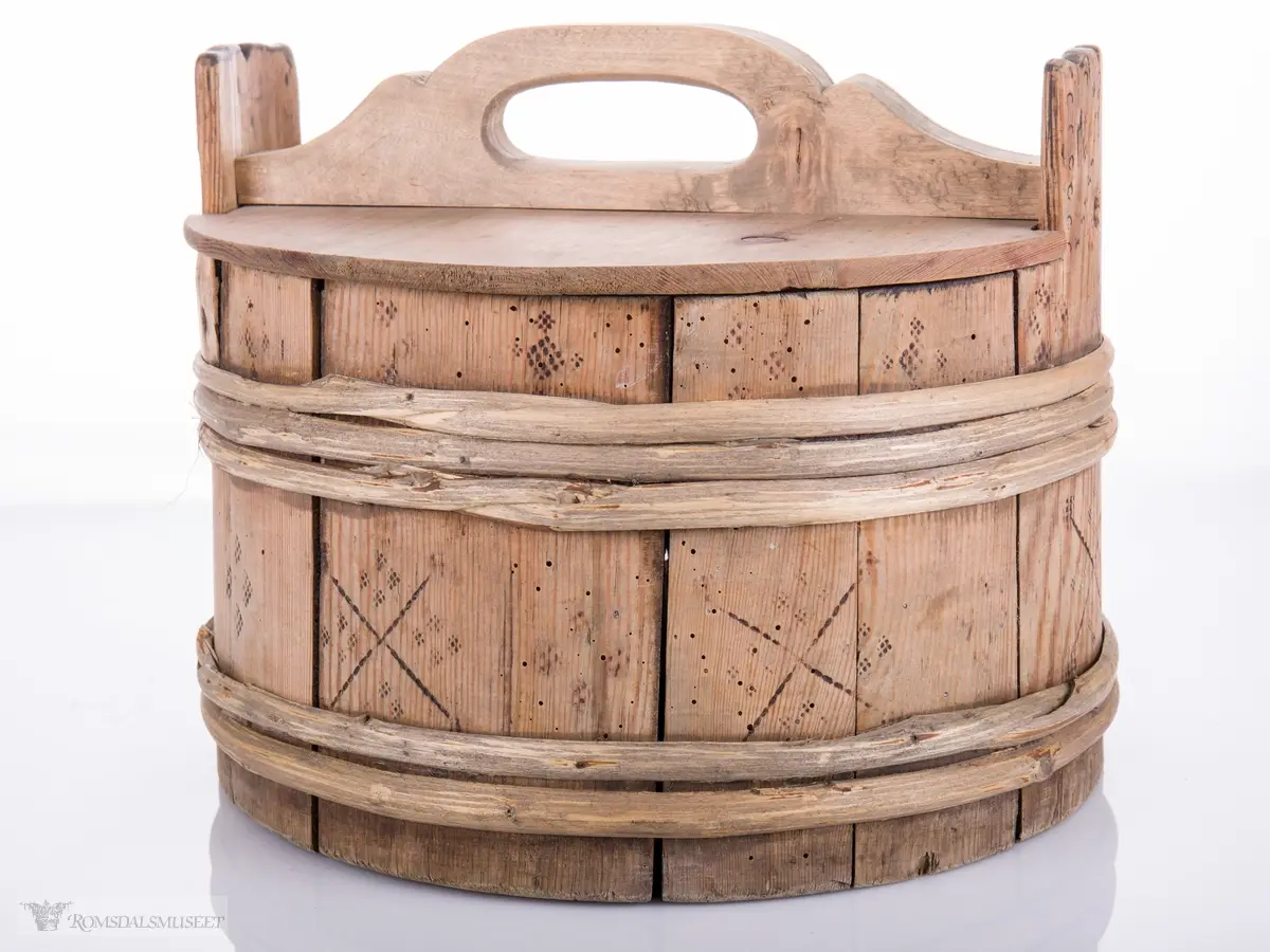 Lagget ambar med ører og lokk med hanke. Omslått med gjorder oppe og nede.