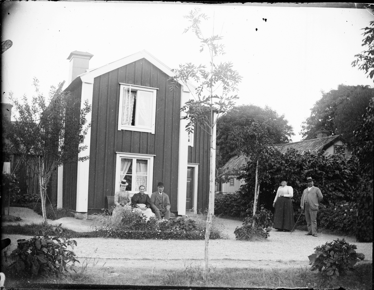 Män och kvinnor i trädgården vid bostadshus, Södra Tullportsgatan 20, Östhammar, Uppland