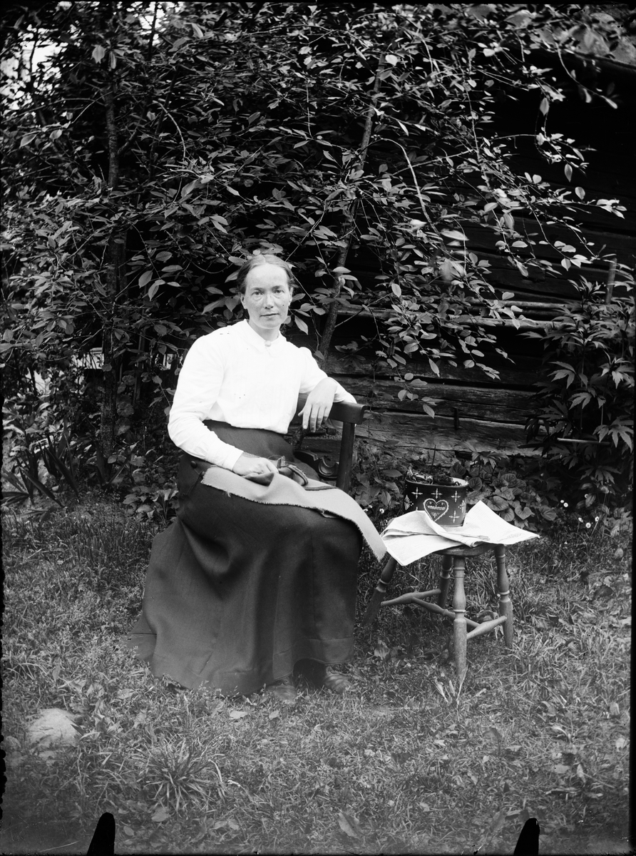 Kvinna med handarbete i knät, Östhammar, Uppland