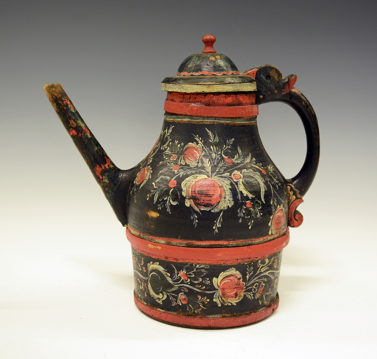 Tutekanne i tre. Fra protokollen: Ølkande med tut, laak og hank; dreiet arbeide i 2 halvdeler; rosemaling paa sort bund.