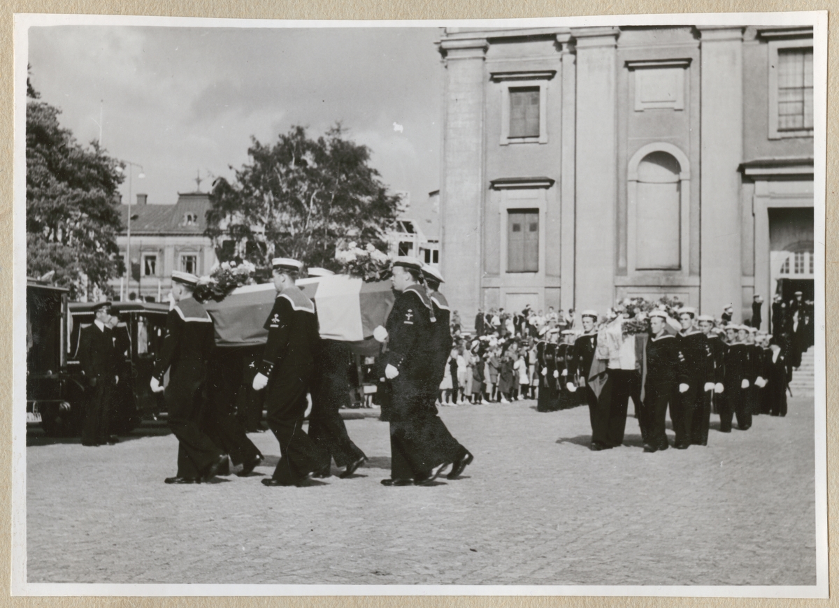 Bilden visar jordfästningen av sex av offren från ubåten Ulven fredagen den 6. augusti 1943 i Fredrikskyrkan. Sjömän bär likkistor ut ur kyrkan.