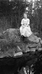 Fem bilder av en ung kvinne ved et lite tjern. På to av bild