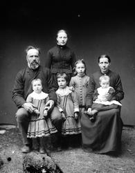 Familiebilde. Mor og far med fem barn, døtre. Fotografiet er