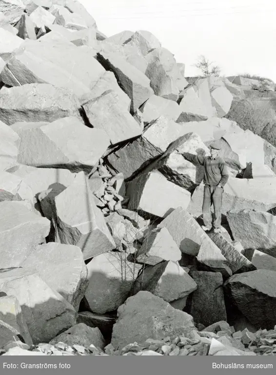 En man står bland stenblock i stenbrottet på Rixö