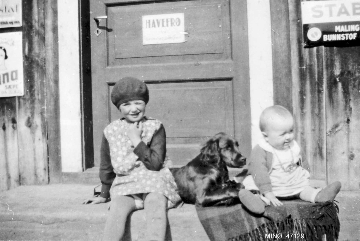 To små barn og en hund på ei stentrapp