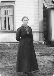 Kvinne foran bolighus