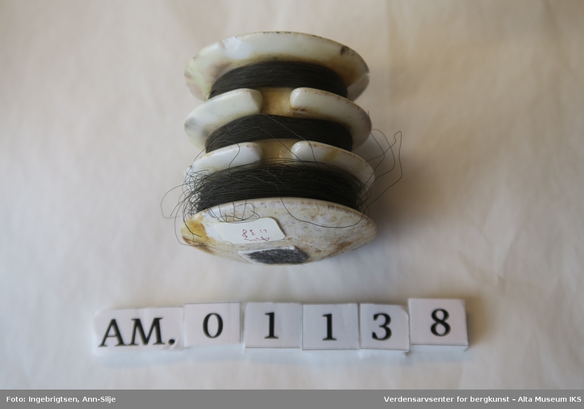 Form: sylinder formet porselenstykke med tre sporer og hull i midten. I sporene er det surret kobbertråder.