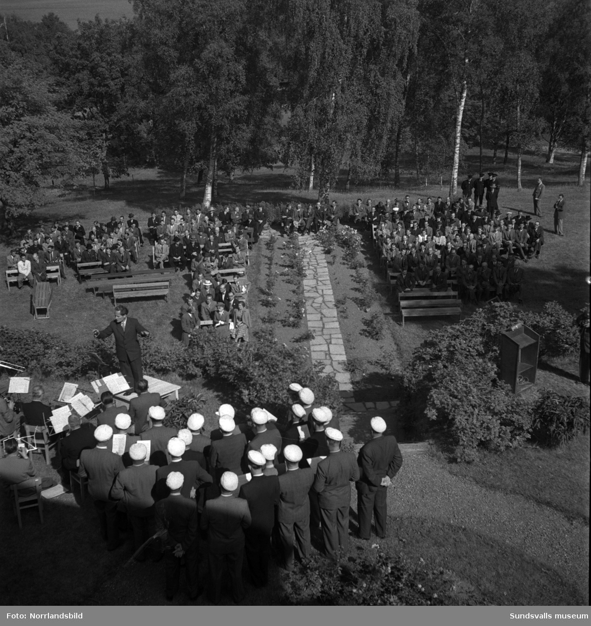 Tunadals sågverks hundraårsjubileum firas vid Tunadals herrgård. Stor publik i parken med tal av bland andra Axel Enström, förtäring, serveringspersonal och jubileumscigarrer.