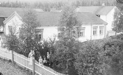 Familie i hage på gardsbruk. Gården Fellinga, S. S. Akre med