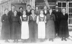 Gruppebilde, personer foran bolighus