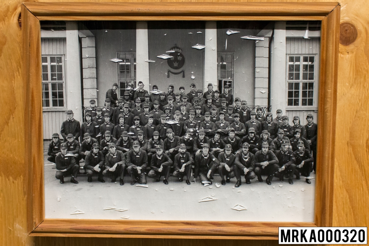 Fotografi taget på befäl och soldater som genomfört grundläggande soldatutbildning på 1:a Batteriet KA 2.
Fotografiet taget utanför gymnastikhallen på Gräsvik KA 2.