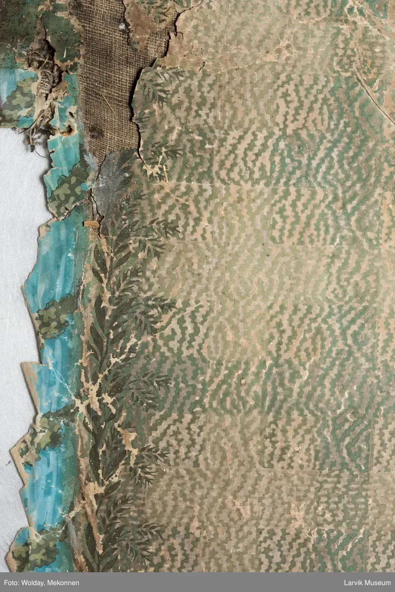 |Tapeten er påmalt tapetborder og brystning. Fra Hovland gård i Larvik.
Den øverste, brede borden: Gerlander/draperi med blomsterranker.
Den nederste, smalere borden: Tekstilbord med blomster. Øver døren til høyre: Stillebenmotiv med blomster og frukt.