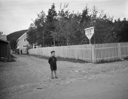 Liten gutt i matrosdress står i vegen bortenfor Furuly, Våle