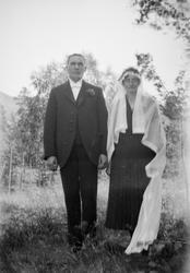 Brudeparet Marie og Hans Kleiven står ute. Hun har mørk kjol