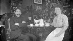 Mann og kvinne ved kaffebordet i stuen.