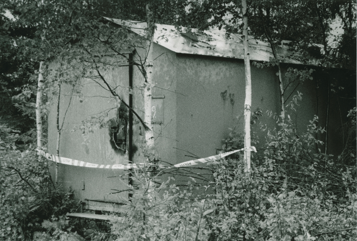 Våpentyveri ved Forsvarets våpenlager i Enebakk. Bilde av bygning med sprengt dør.
Avbildet person: Lensmannsbetjent Knut Bjørnstad.