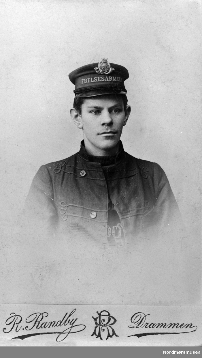 Foto av en ung mann i uniform fra Frelsesarmeen. Se også KMb-2017-021.1603. Trolig med tilknytning til Kristiansund. Fra Nordmøre museums fotosamlinger.