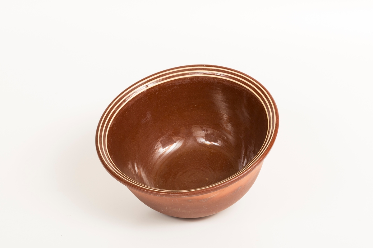 Brun bolle i keramikk med 3 gule striper. Glasert på innside.