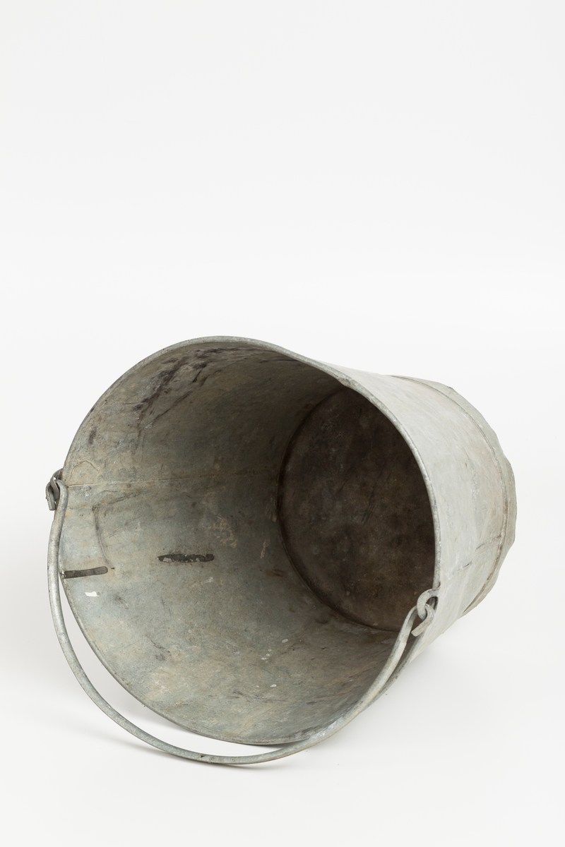 Grå metallbøtte med hank. Sotflekker på innsiden.