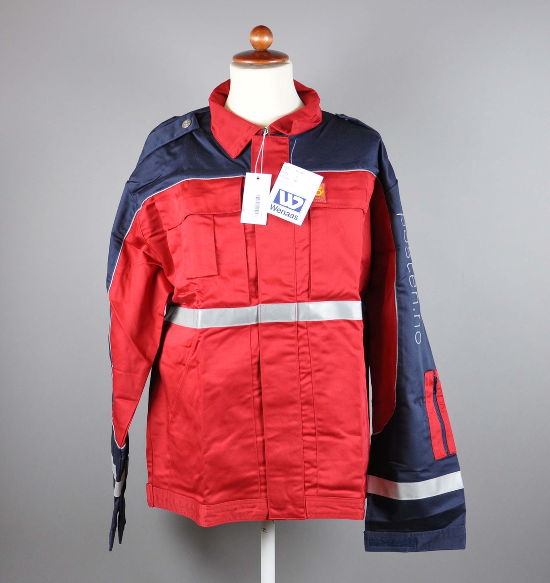 Rød uniformsjakke med postlogo. 4 lommer + lomme for mobil og for penner. Refleksbånd på ermer og liv. Skulderklaffer med kanpper med posthorn.
