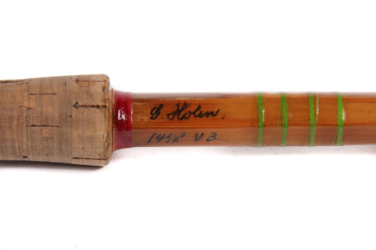 Tredelt fiskestang av type tohands splitcane med ekstra tupp og futeral. Den sekskanta stanga er laga av bambus og handtaket av kork.