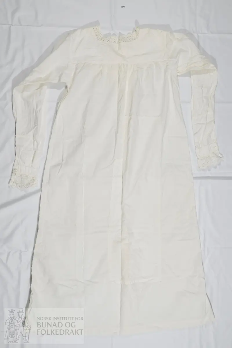 Nattkjole i hvit bomullslerret med påsydd blonde langs halsåpning og mansjetter. Bærestykke med firkantet halsåpning påsydd bomullsblonder, engelsk blonde. Ermene er satt rett i og er sydd med to sømmer i indresøm. Ermet kan være forlenget, med en søm tvers over nede på underermet. Splitt og mansjett med knapp og knapphull. Påsydd bredt blondebånd på mansjettene.