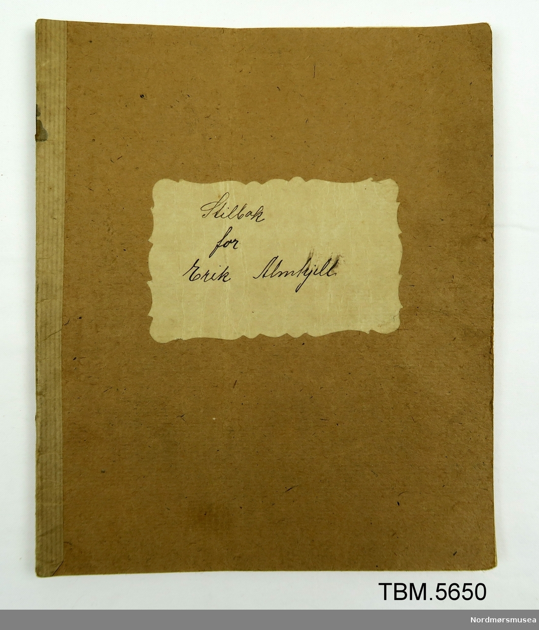 Brun skrivebok som har tilhøyrt Erik Almhjell. Stilen er retta og kommentert av Anders Todal 22/2 1921.