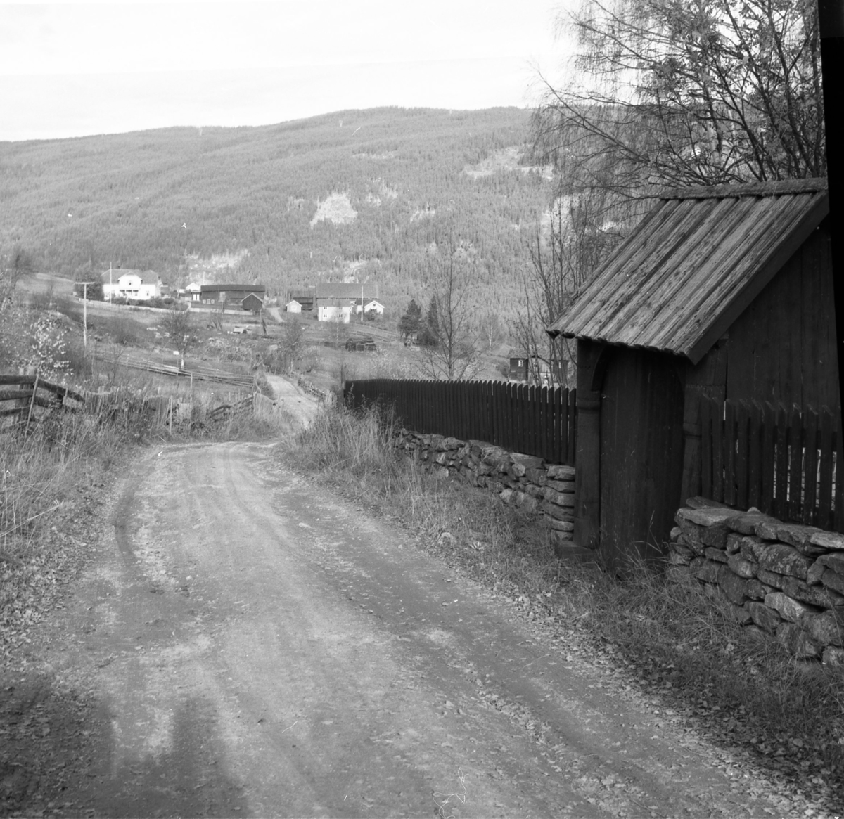 Den gamle kyrkjevegen framom porten og kyrkjegardsmuren (Ill. i "Boka om Gol" b.II, s.86)
Gol prestegard i bakgrunnen