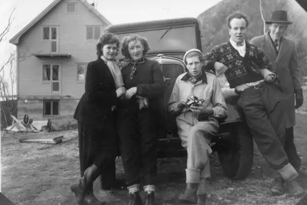 Personer framfor en liten lastebill, byggeplass