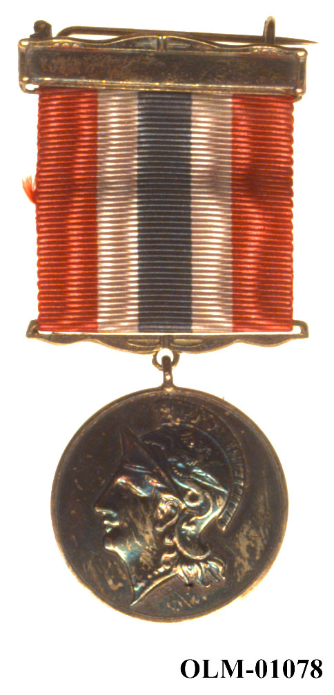 32 forskjellige medaljer og merker i ramme.
Bilde 7 er deltdagermerke fra Amsterdam 1928.
Bilde 18 og 19 er deltagermedalje fra Amsterdam 1928.
Bilde 20 og 21 er sølvmedaljen fra Antwerpen 1920.
Bilde 26 og 27 av bronsemedaljen fra Paris 1924.
Bilde 39 og 40 minnemedaljen fra Antwerpen 1920.