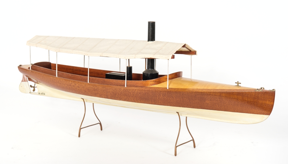 Fartygsmodell av ångdriven båtmodell. Halvdäckad förut, Akterut och midskepps maskin- och sittrum täckt med solsegel. Fasta skrån av koppartråd. "Ljungströms ångmotor(!)båt"