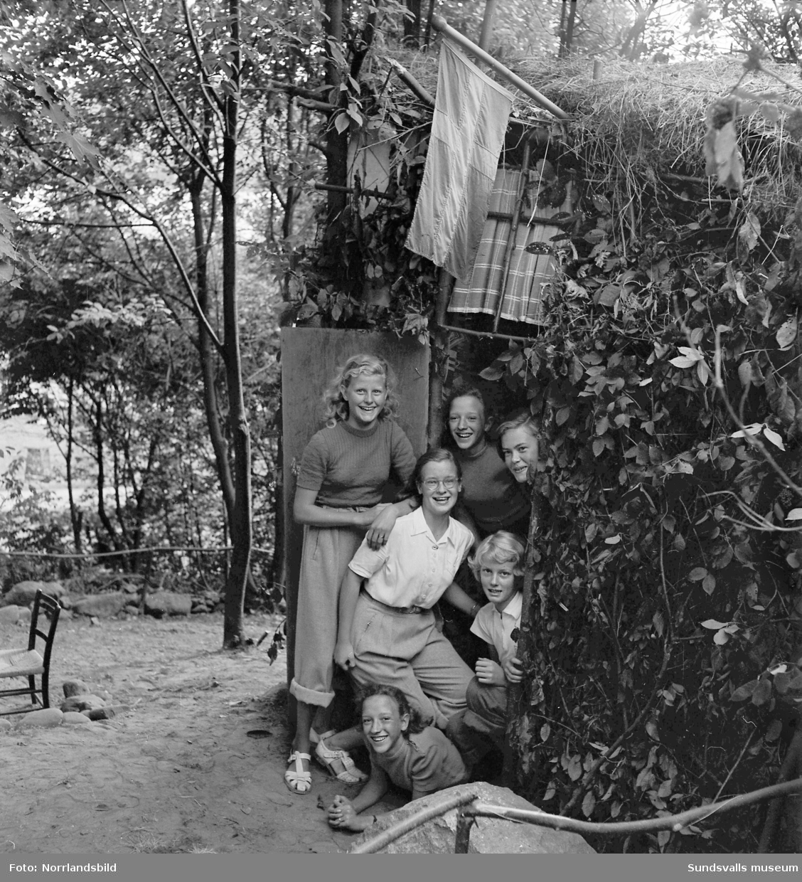 Sex glada Skönsbergsflickor har byggt sig en fin koja/hydda av grenar, ris och löv.