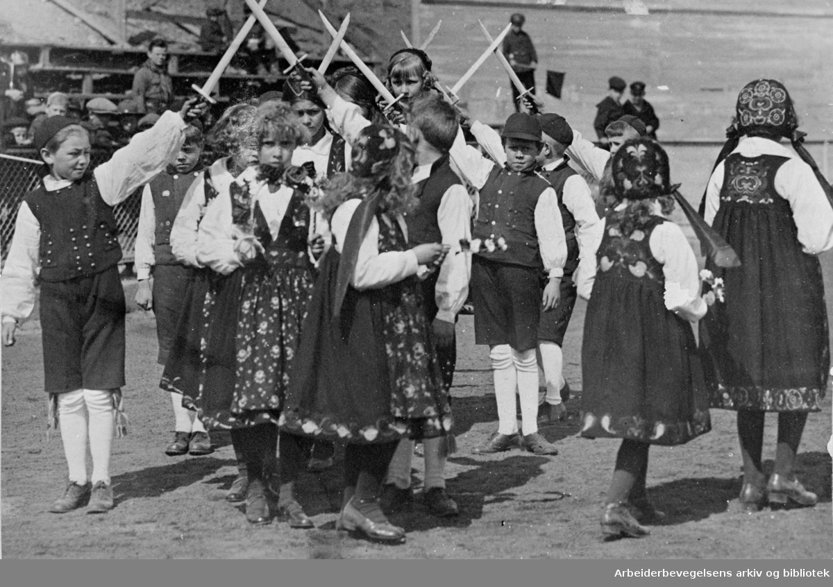 1. mai 1925, fra barnestevnet på Bislett stadion. Leikarring fra et barnelag som opptrer dansespillet "Falkvor Lommanson" (Sverddansen, Fakkeldansen).