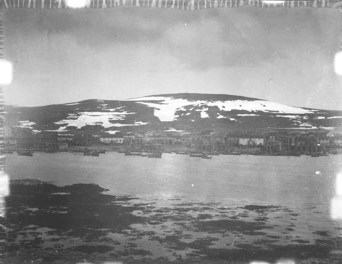 Kiberg i 1908. En del av bygda fotografert fra sjøen (ut fjæra). Sjø og fjæra i forgrunnen.