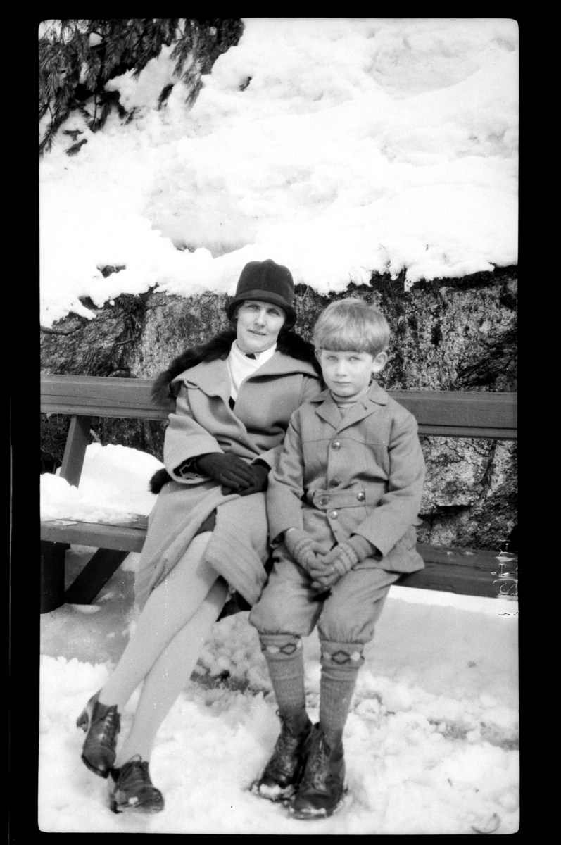 Mor og sønn, Hilda og Rolf Sundt Jr., på en benk i snøen. Fotografert 1928.