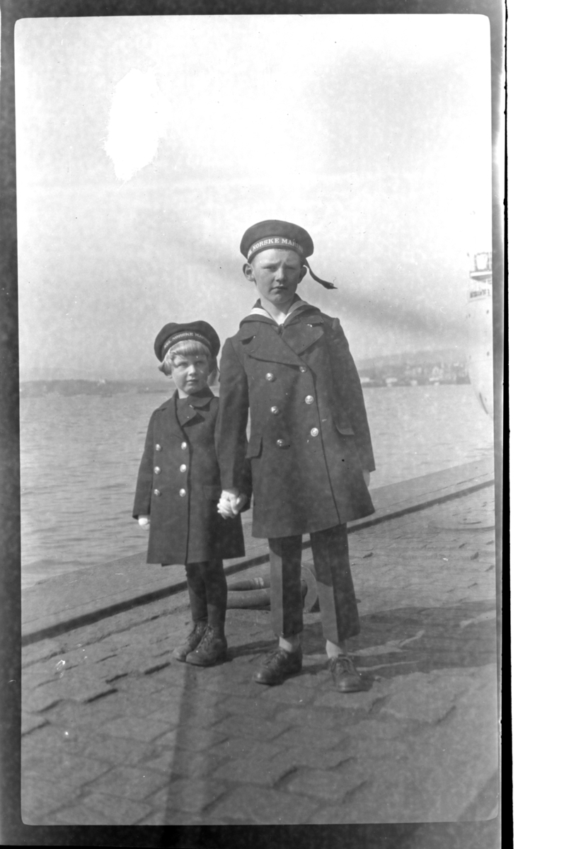 Brødrene Rolf Jr. og Julius Sundt kledd i matrosklær på kai, antagelig i Oslo. Fotografert 1925.
