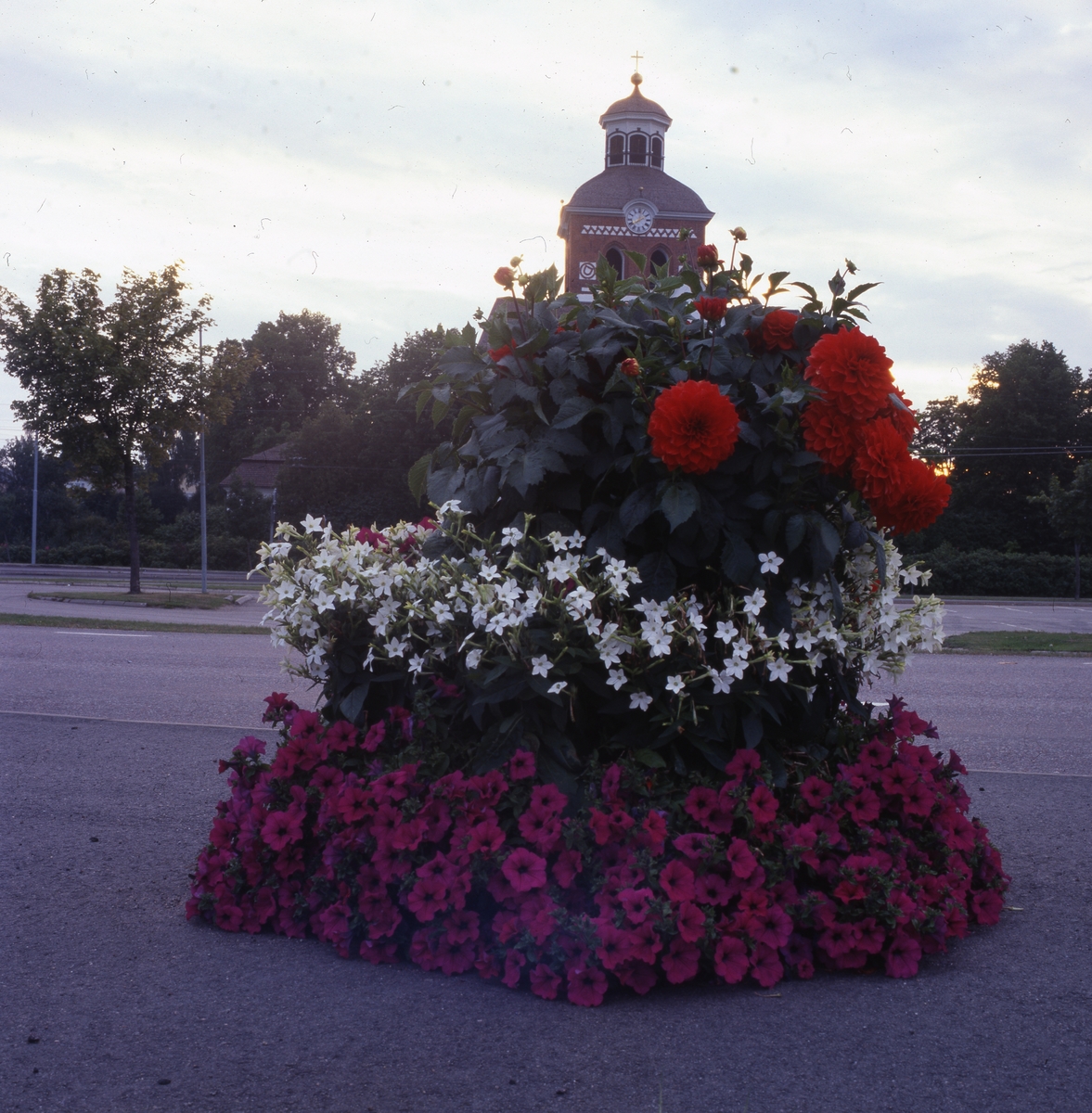 Praktfull blomsterurna med kyrkan i bakgrunden, Bollnäs 25 augusti 2001.