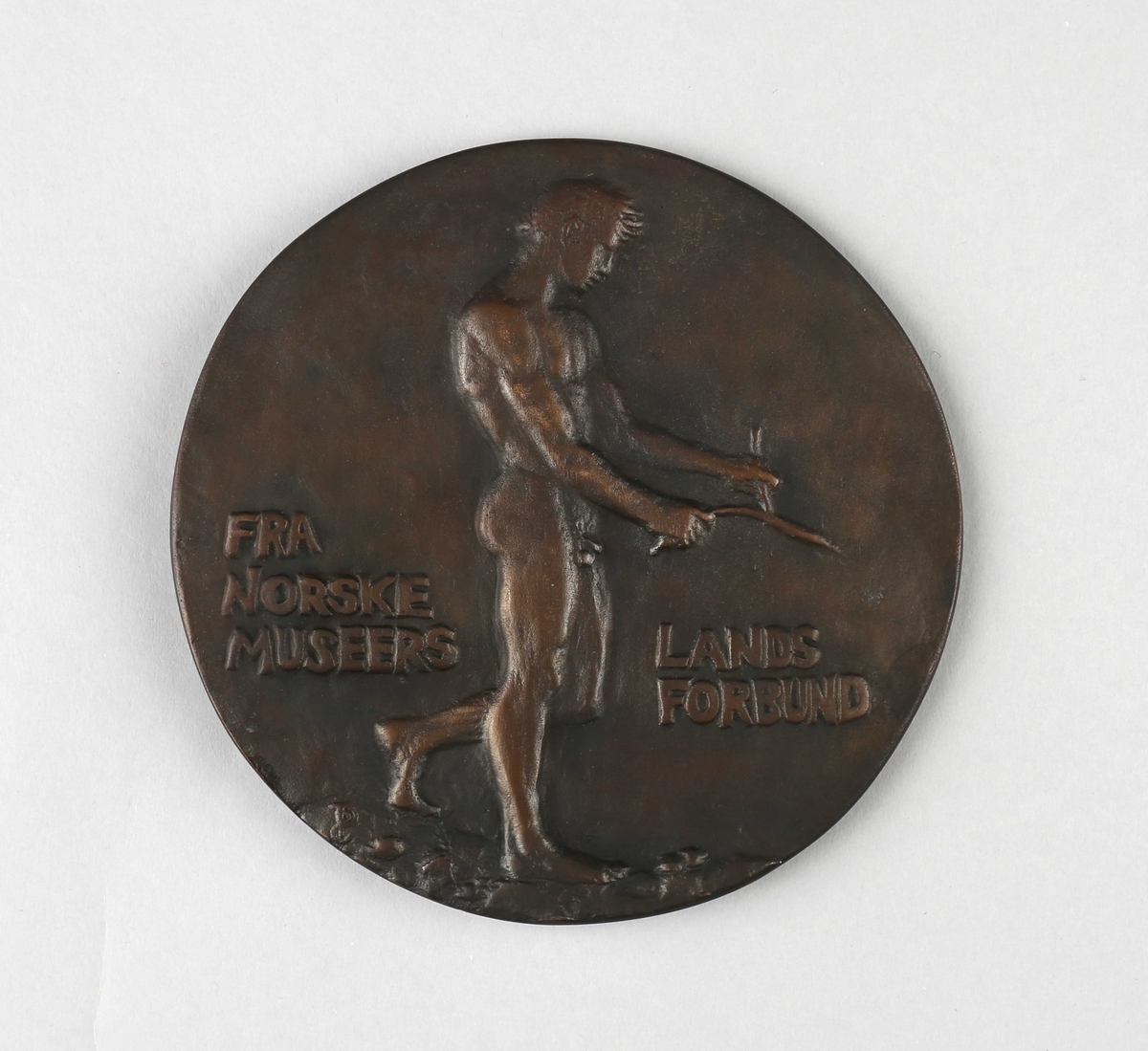 Minneplate med relieff av Hans Aall (forside) og av naken mannsperson med ønskekvist (bakside).