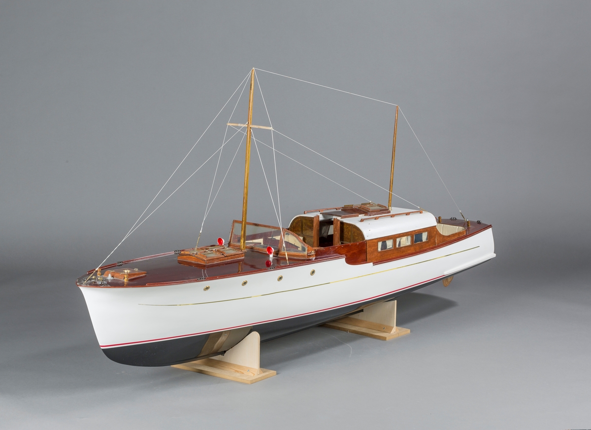 Modell av motorkrysseren "Bello". En Furuholmenkontruksjon. Kahytt med salong, og åpen styrekonstruksjon. To enkle master. Ikke originale båtstøtter, laget av museet ved inntak.