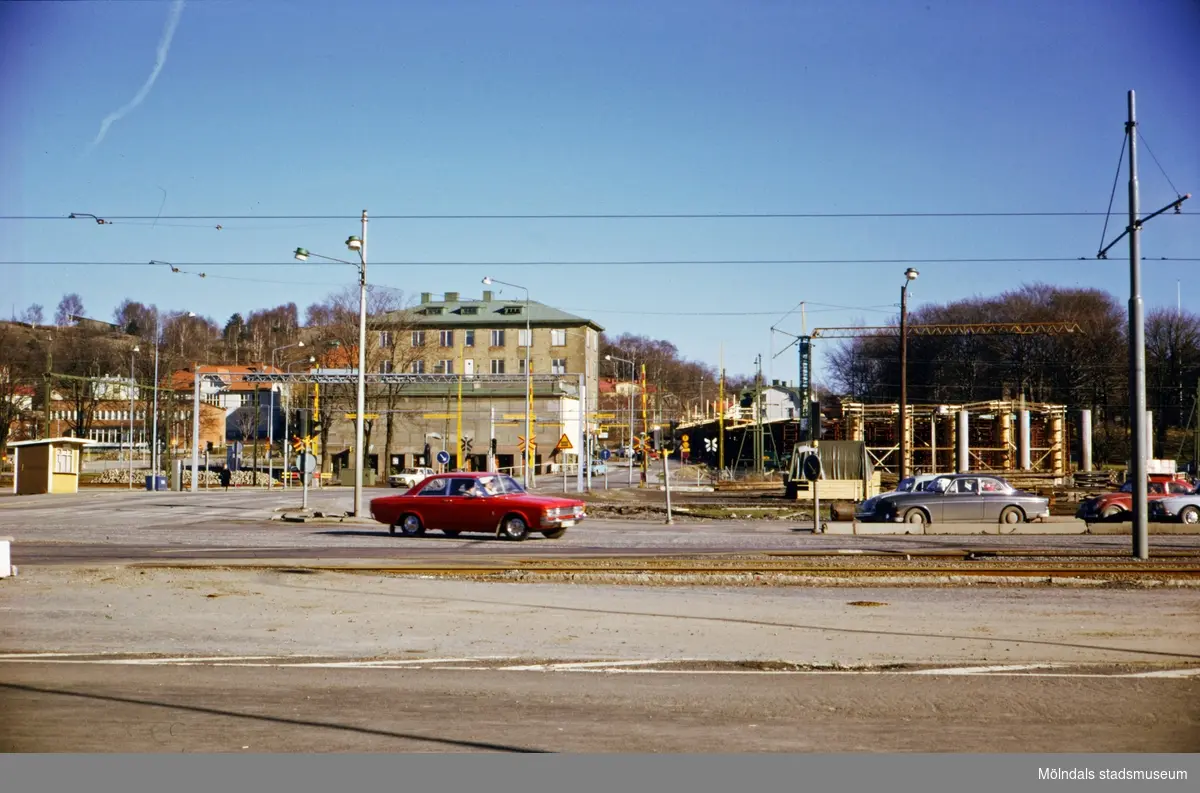 Vy från Göteborgsvägen över Mölndals Bro mot Kvarnbygatan, ca 1974-1975. I mitten ses huset Kvarnbygatan 1, numera Nämndemansgatan 1. Till höger ses byggnationen av den nya Mölndals Bro.